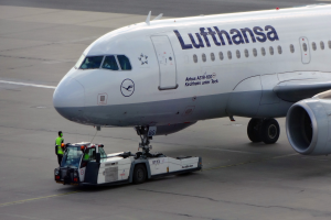 Ein Lufthansa Airbus A319-100 steht auf der Startbahn des Frankfurter Flughafens, mit einem Fahrzeug und einer Person in der Nähe, bereit zum Abflug.