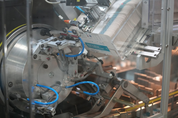 Automatisierte Verpackungssystemmaschine auf einem Fabriktisch mit unscharfen Hintergrundobjekten.