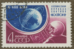 Eine Briefmarke mit einem Mann im Weltraumanzug mit entschlossener Miene, umgeben von der Schrift "Marke" in fetter, weißer Schrift.