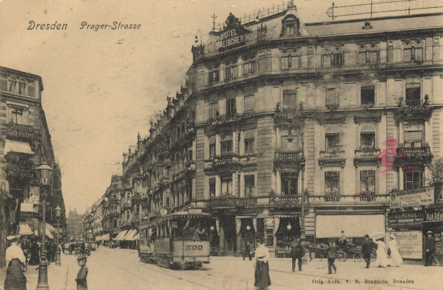 Ein Schwarz-Weiß-Foto einer Stadtstraße in Dresden, Deutschland, das eine Gruppe von Menschen, Fahrzeuge, einen Straßentisch, ein Schild, Gebäude mit Fenstern, Pflanzen und einen bewölkten Himmel zeigt.
