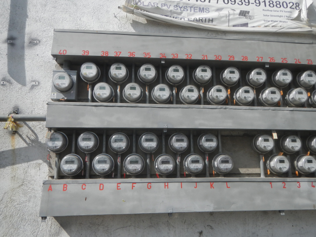 Nahaufnahme eines Stromzählers an der Seite eines Gebäudes mit einer Banneranzeige oben.