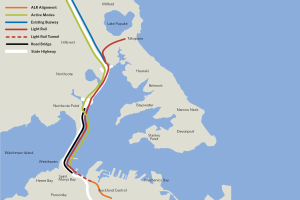Eine detaillierte Stadtkarte mit einer roten Linie, die den vorgeschlagenen Bahnweg anzeigt, zeigt Haltestellen, umliegende Gebiete und Text mit zusätzlichen Routeninformationen.