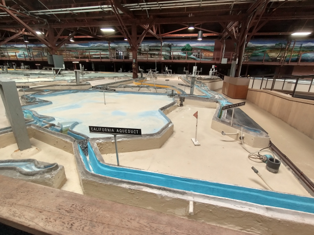 Indoor-Wasserpark mit mehreren Rutschen, Deckenbeleuchtung, Wandgemälde und Minigolfplatz.