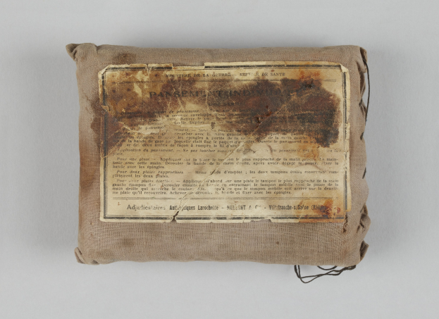 Kleiner Verbandkasten mit einem informativen Blatt oben drauf.