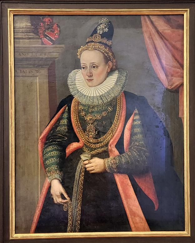 Porträt der Queen Elizabeth I. von England in königlicher Kleidung mit Krone und Tiara, das Haar zu einem Knoten gebunden, mit einem würdevollen Gesichtsausdruck, in einem Rahmen an der Wand gehängt.