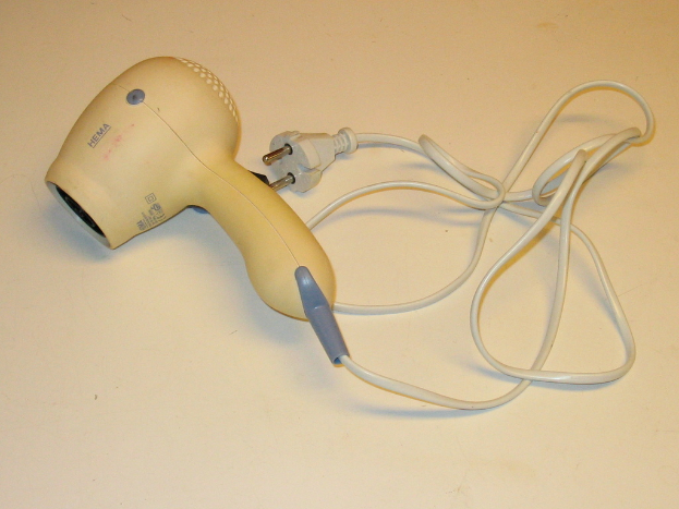 Ein Föhn und Kabel auf einer weißen Oberfläche.