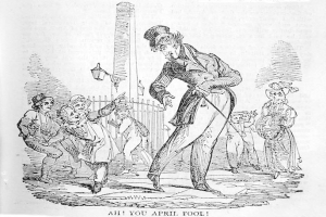 Cartoon of a man in a top hat and tails standing before a crowd, with a pole and fence in the background, labeled "April Fool's Day" at the bottom.