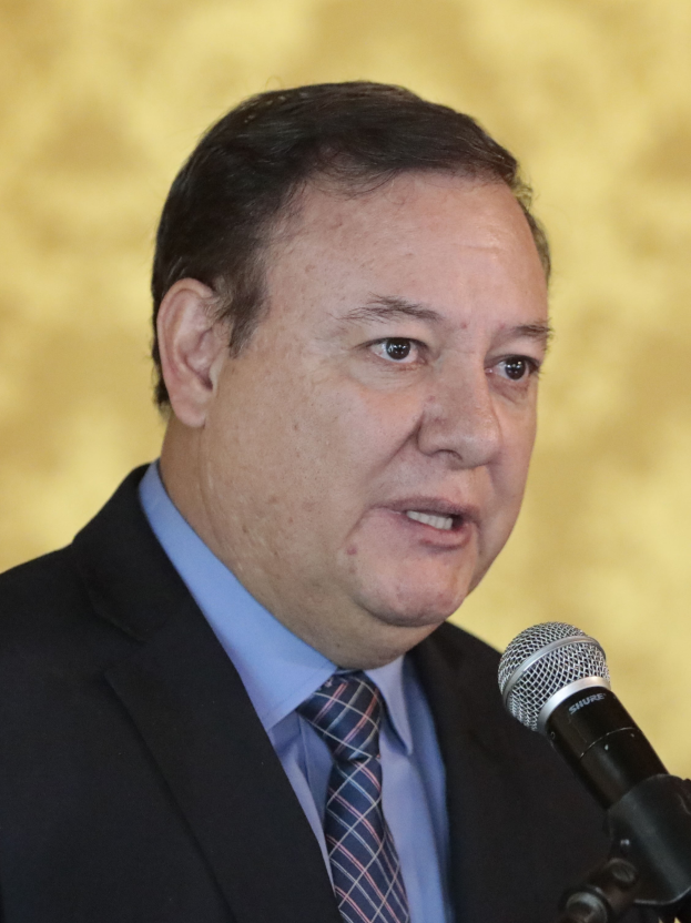 Ein Mann in Anzug und Krawatte, der in ein Mikrofon spricht, identifiziert als Generalstaatsanwalt.