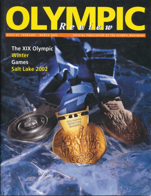 Ein Buch mit dem Titel "Olympische Zeitschrift" mit mehreren Medaillen in verschiedenen Größen und Farben und fetter Schrift auf dem Cover.