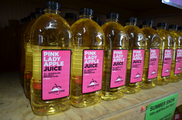 Eine klare Glasflasche mit einem Etikett, auf dem "Pink Lady Apfelsaft" steht und rosafarbene Fl√ľssigkeit enth√§lt.