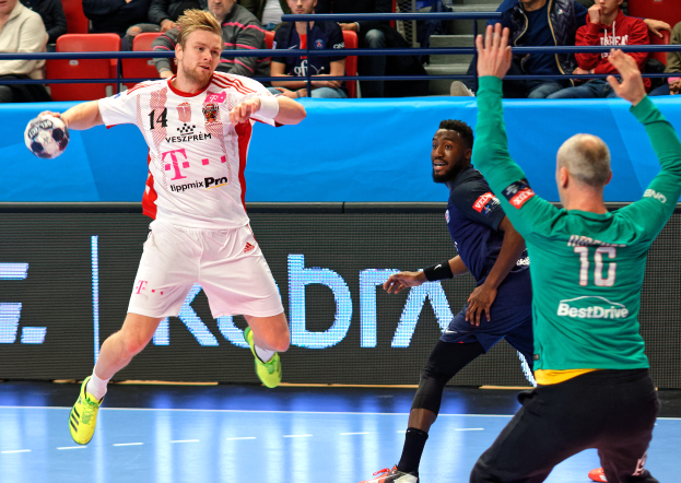 Eine Gruppe von Männern, die Handball auf einem Feld spielen, mit einem Ball in der Mitte der Aktion und Zuschauern im Hintergrund bei der Futsal-Weltmeisterschaft 2019, die ein Spiel zwischen Bayern München und Paris Saint-Germain beobachten.