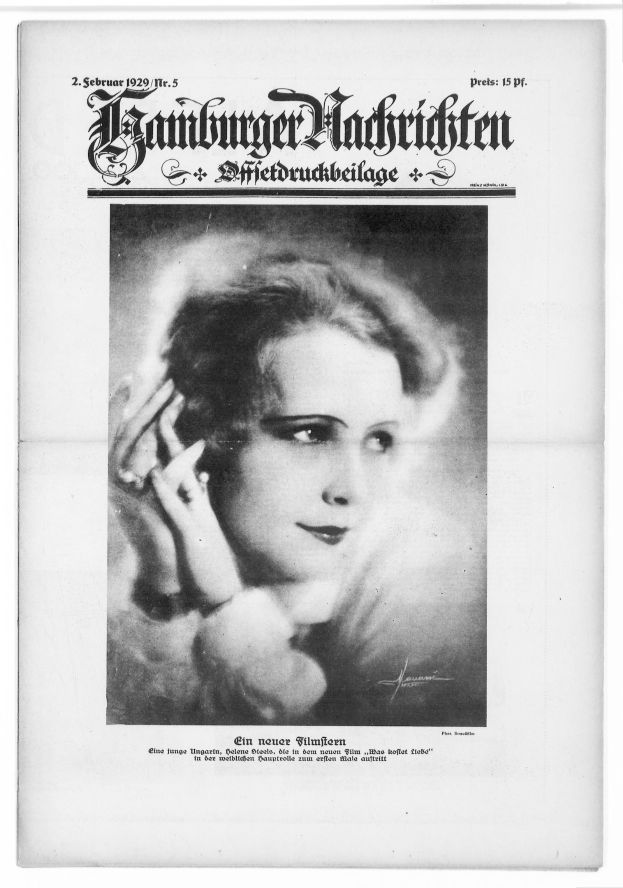 Schwarz-weiß-Porträt einer Frau in einem weißen Kleid mit einem gemusterten Schultertuch, ihr ernster Blick trifft den Blick des Betrachters.