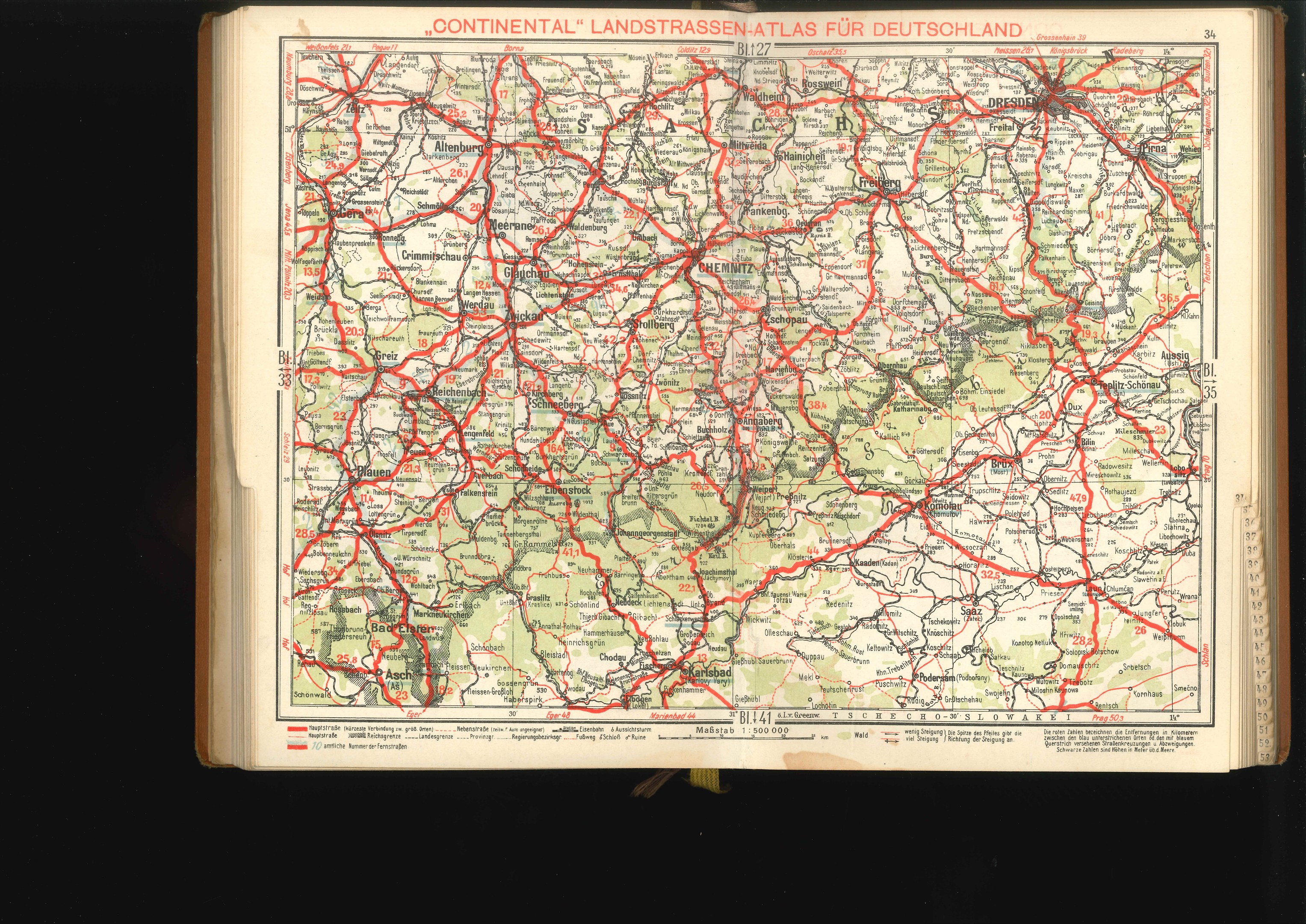 Offenes Buch mit detaillierter Karte von Deutschlands Straßen und Autobahnen auf schwarzem Hintergrund.